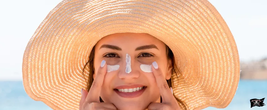 SST - A woman wearing a beach hat and applying sunscreen